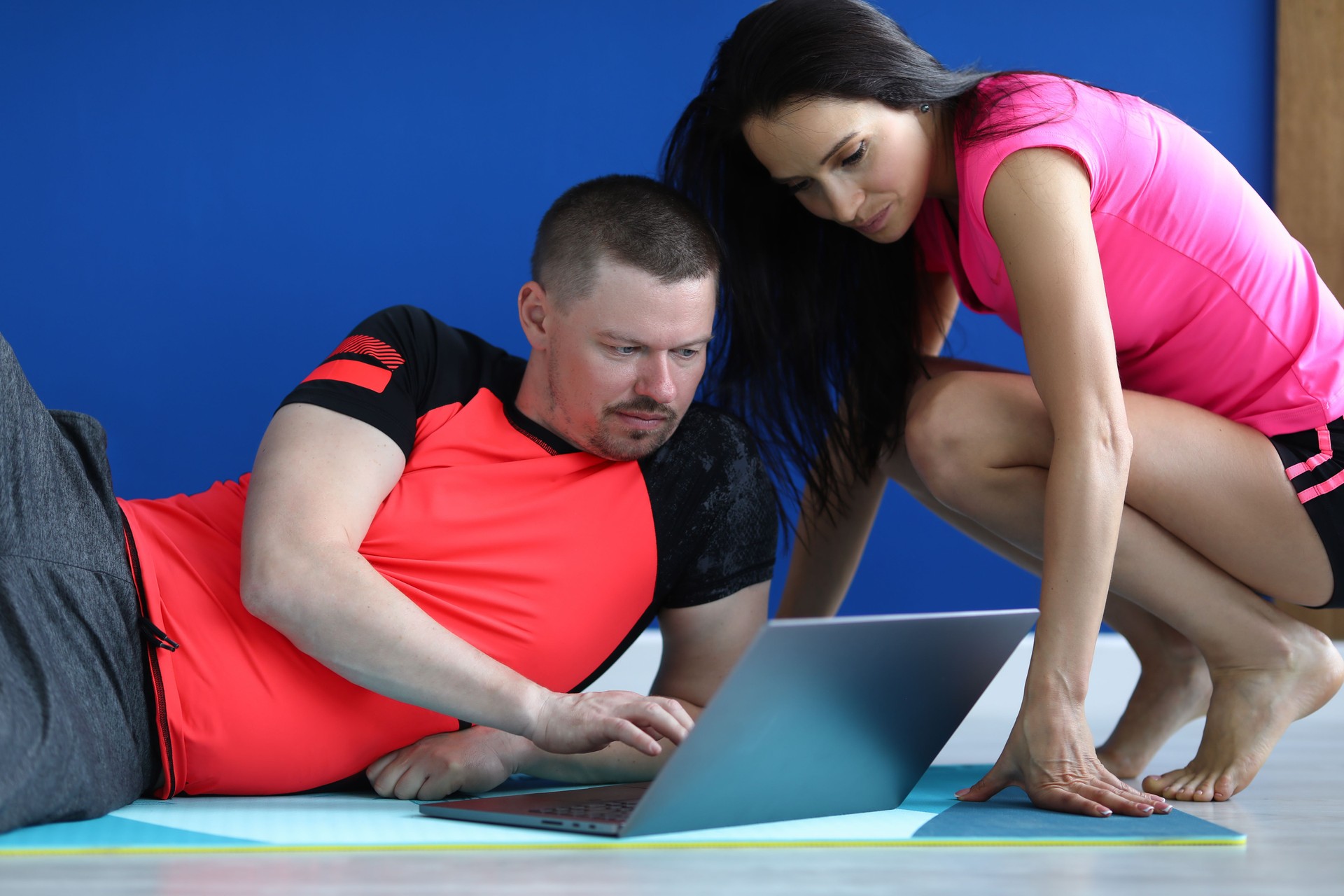 Trainer shows exercises to student on laptop.
